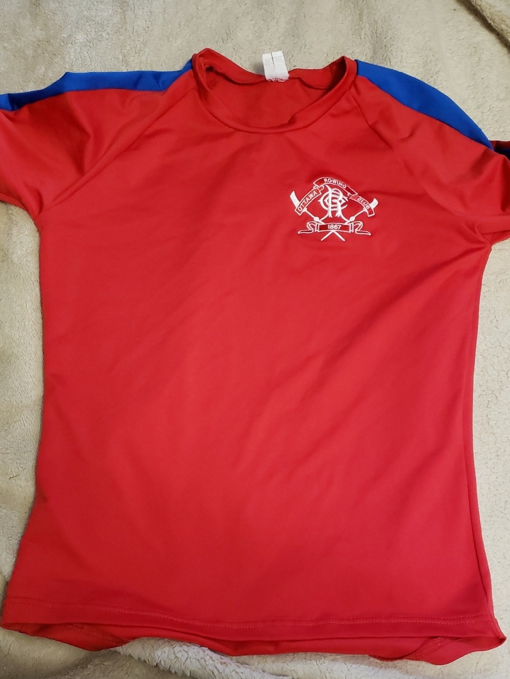 Red Athletic Tee with White Crest and Blue Shoulder Accents